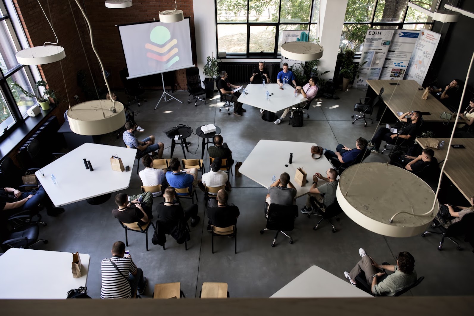 Panelists and audience members gathered around tables at Stage 5